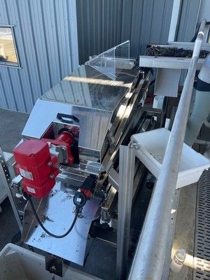 Stainless steel industrial sorting machine with red motor and collection bins.