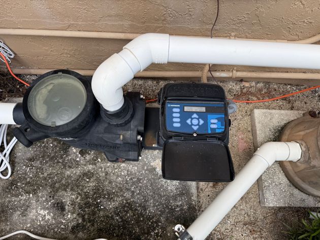 Gloved hand cleaning a dirty bathroom sink drain with a brush