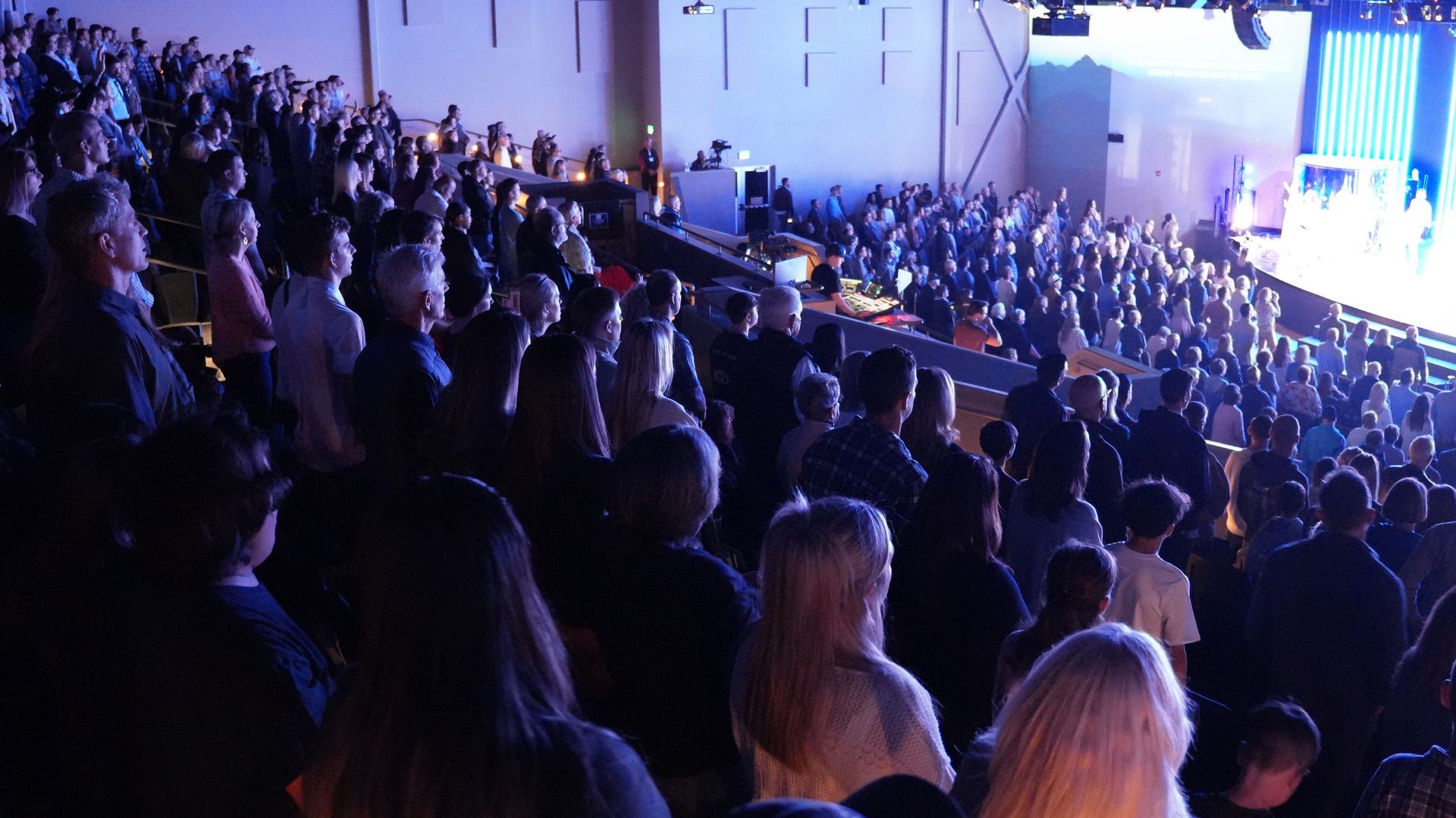 A crowd of people are sitting in a stadium watching a concert.