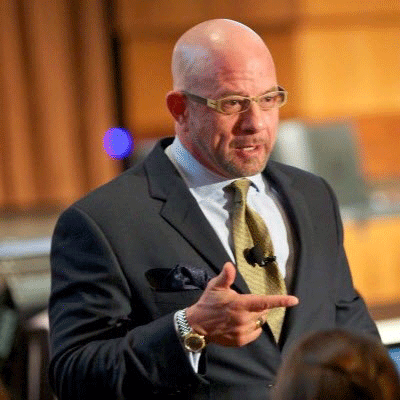 A man in a suit and tie is giving a speech