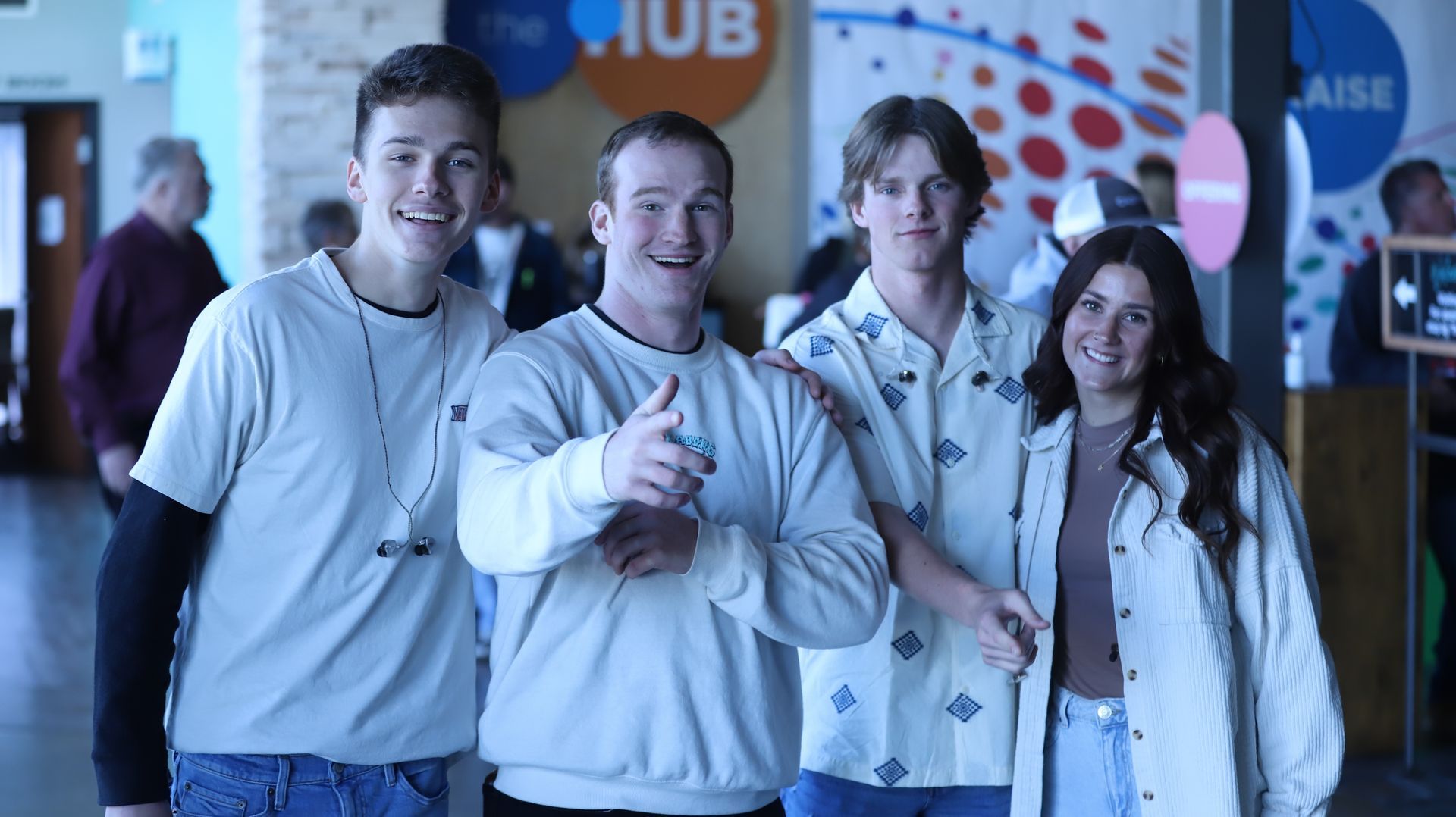 A group of young people are posing for a picture in a hallway.