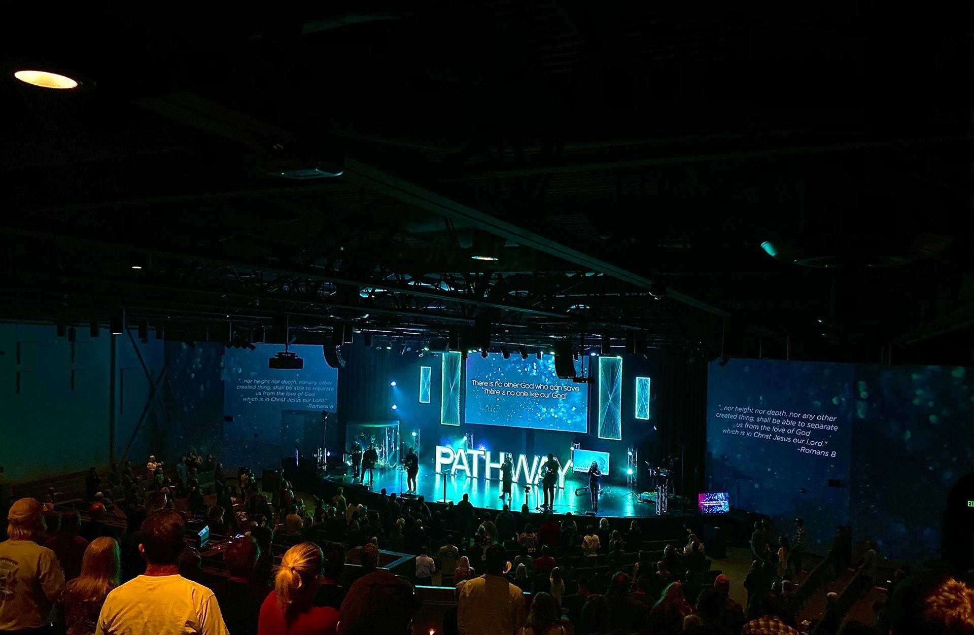 A group of people are sitting in front of a stage that says pathways