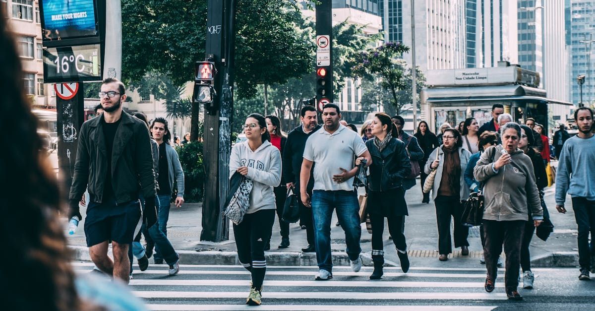 A large group of people are crossing a city street.