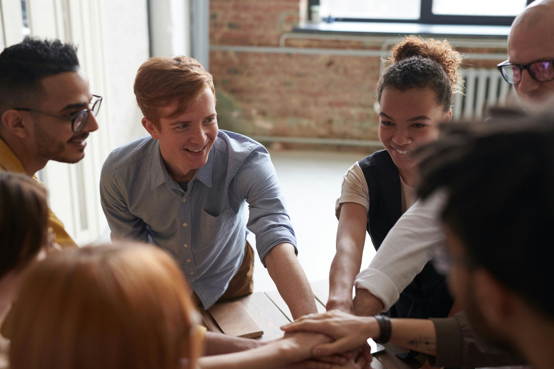 Group of people putting hands together in collaboration.