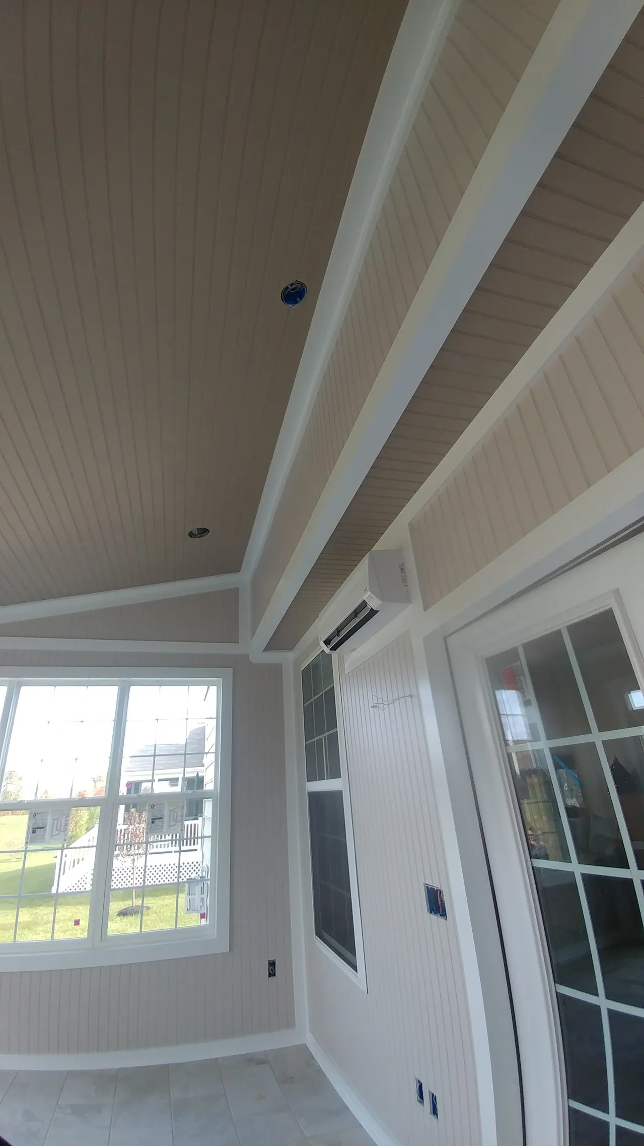 Interior view of a room with a paneled ceiling, windows, and white trim.