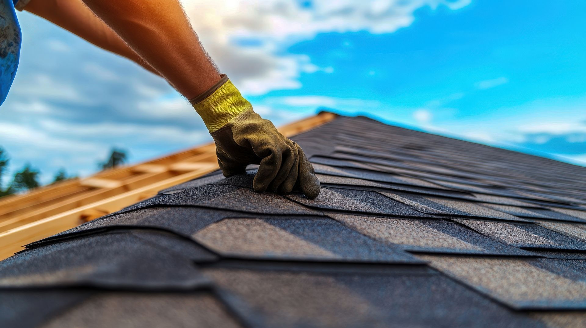 Close-up of expert roofers' hands meticulously laying new shingles during a roof repair.
