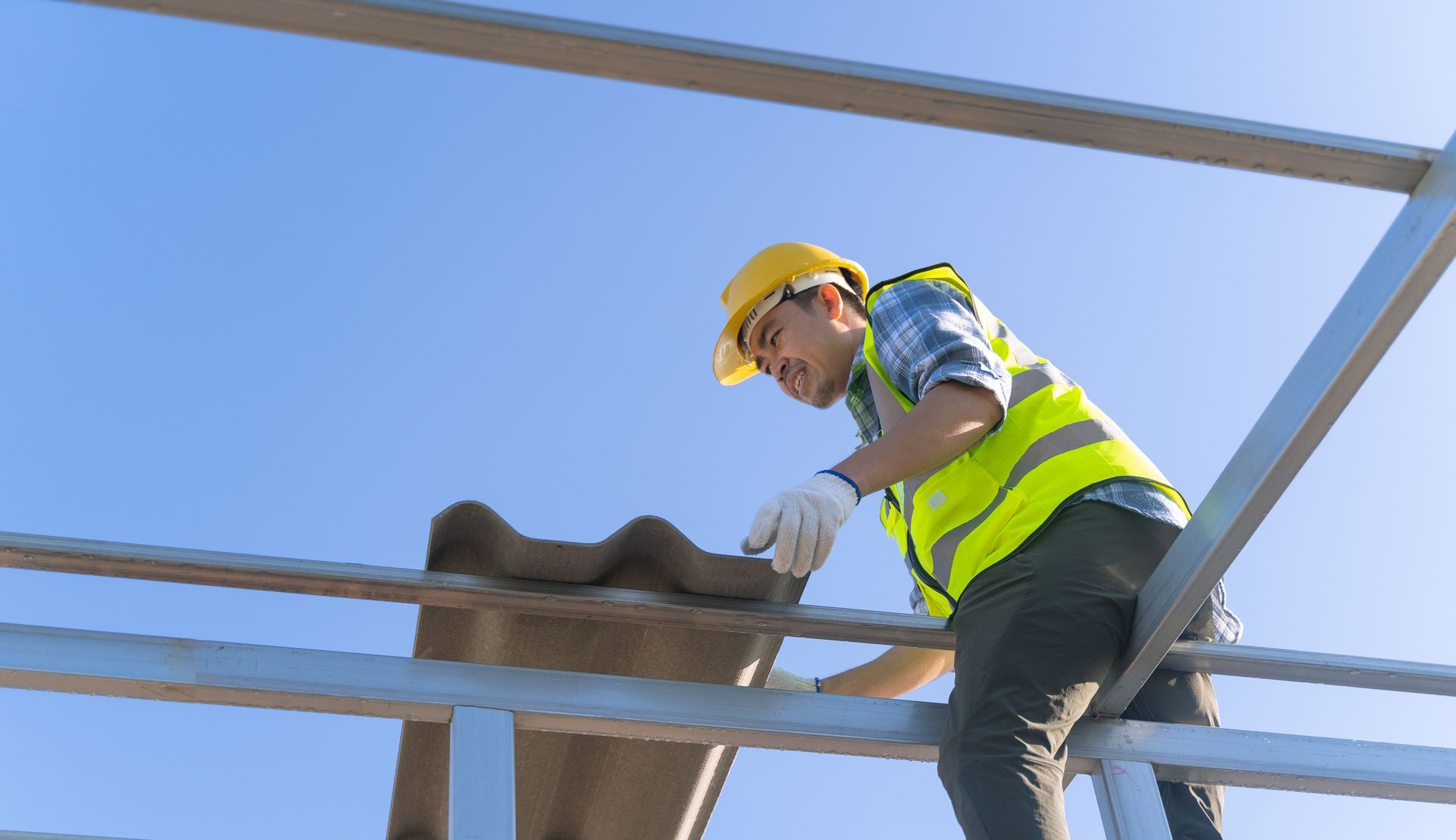 A worker is installing roof tiles.