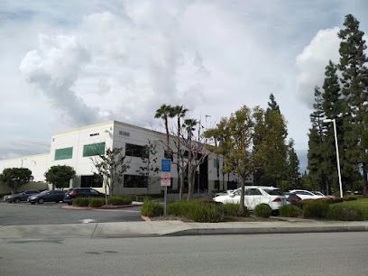 A large white building with a lot of cars parked in front of it.