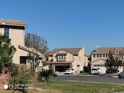 A row of houses in a residential area with cars parked in front of them.