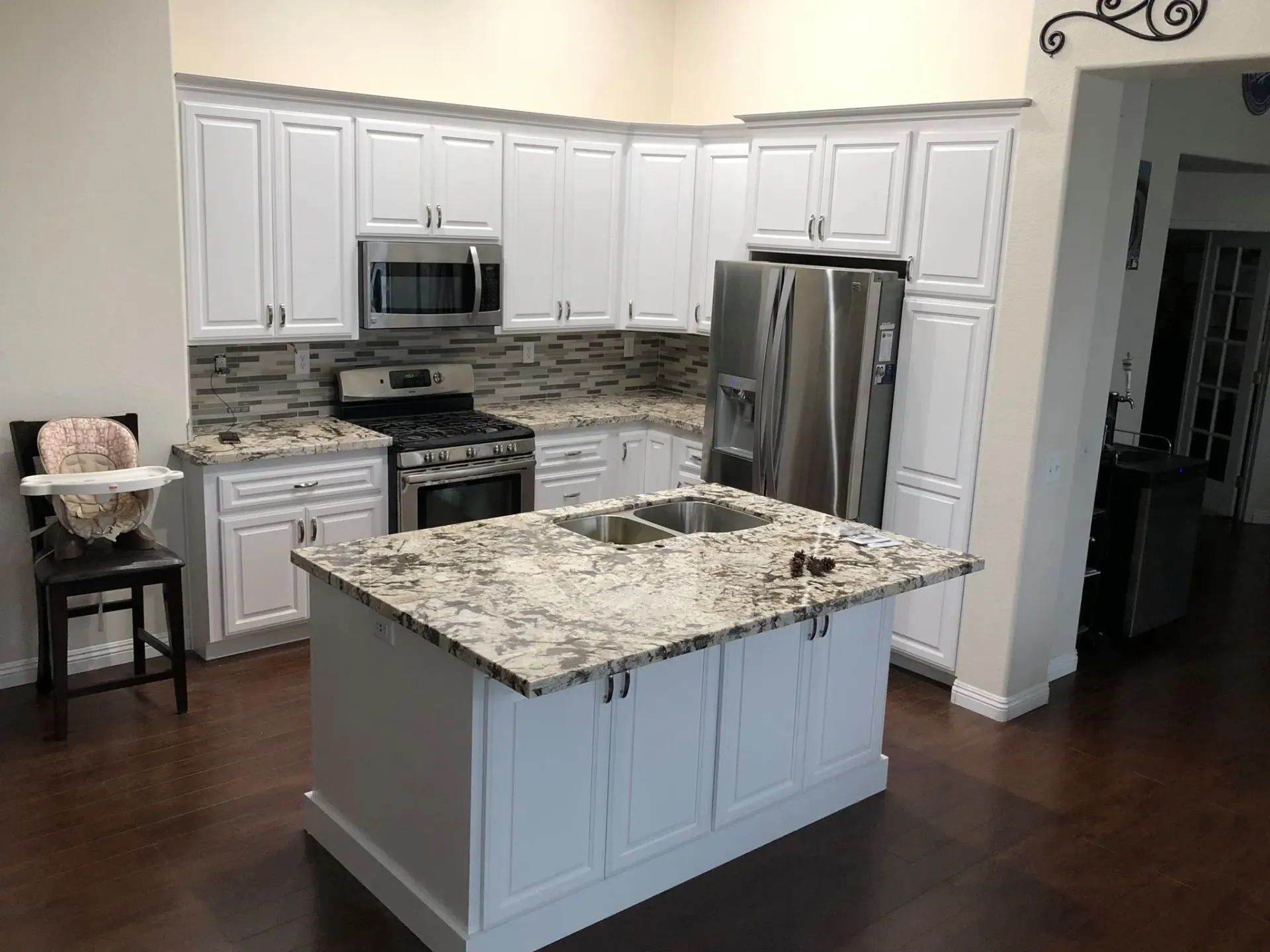 A kitchen with white cabinets and granite counter tops