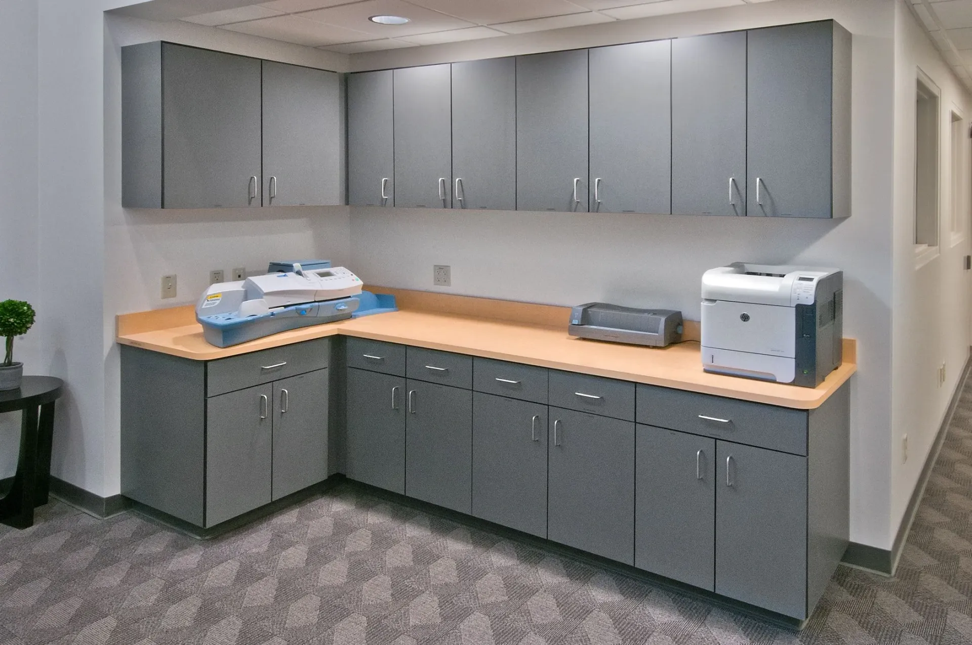 A kitchen with gray cabinets and a printer on the counter