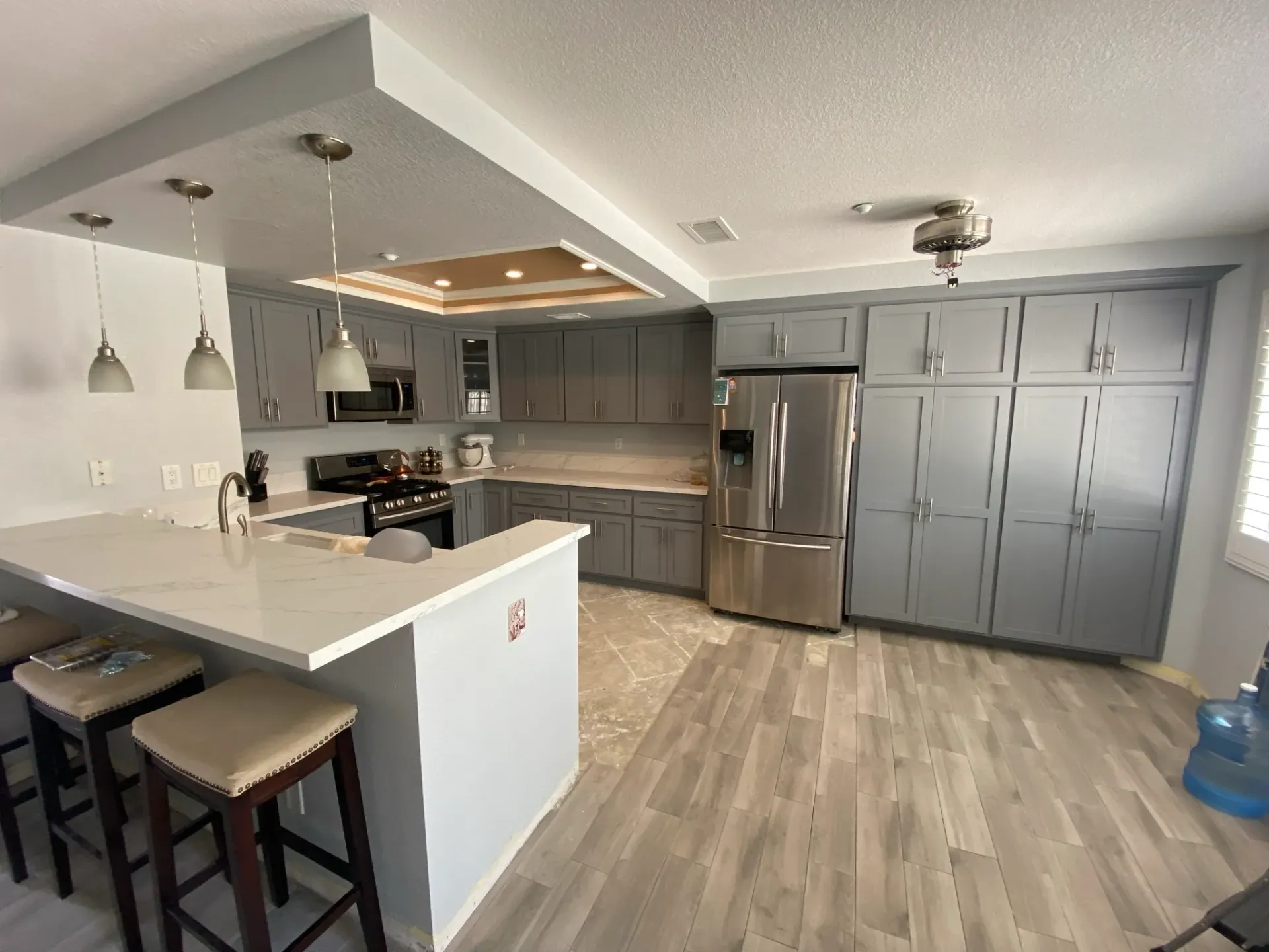 A kitchen with stainless steel appliances and gray cabinets