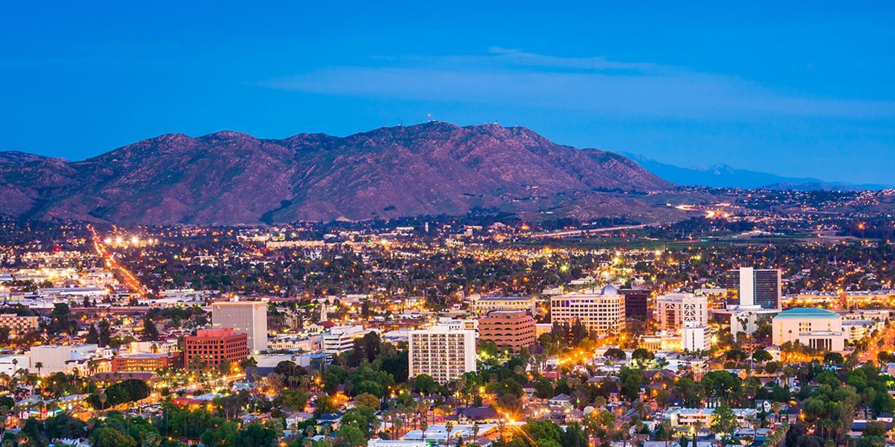 An aerial view of a city at night with mountains in the background.