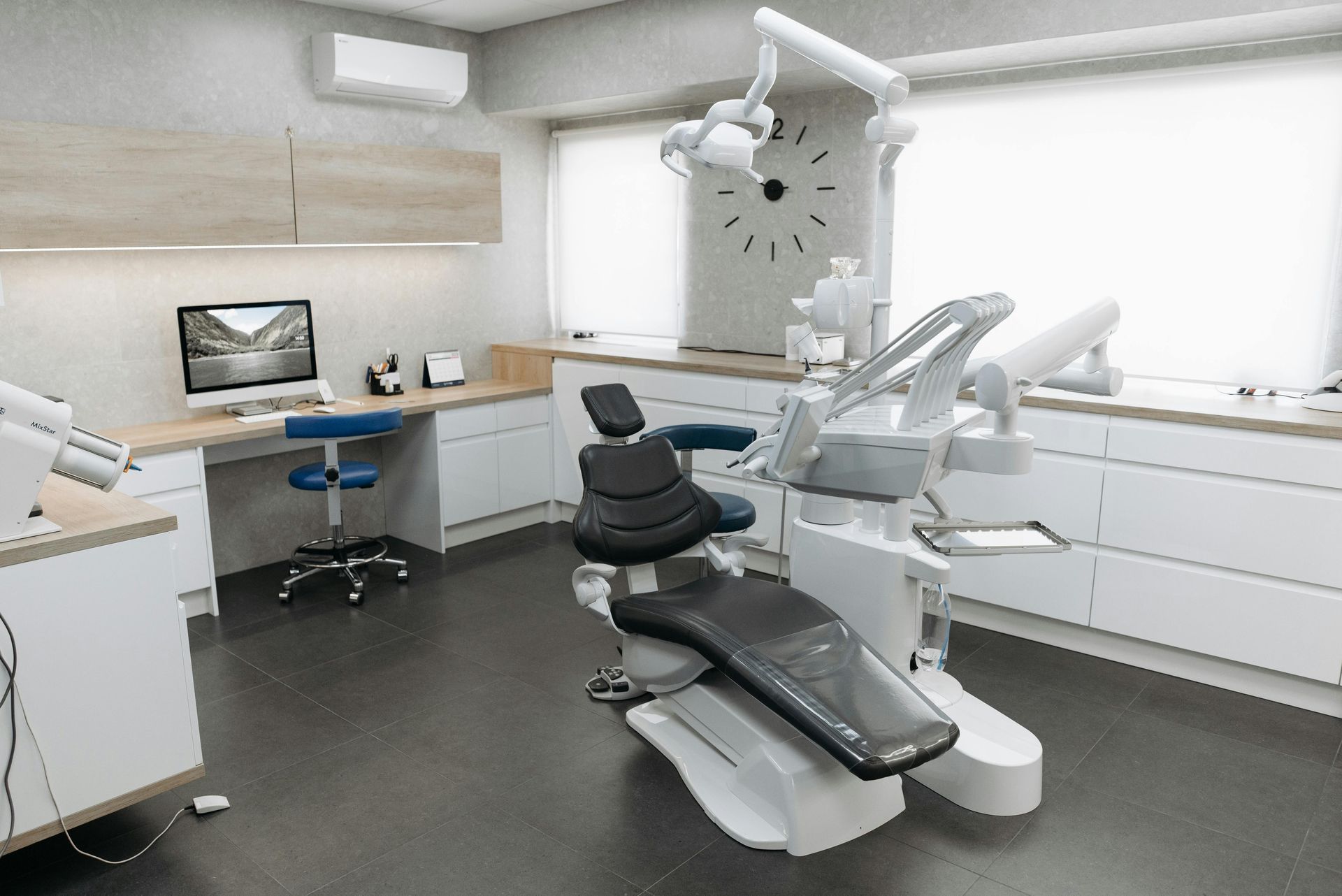 A dental office with a dental chair and a clock on the wall.