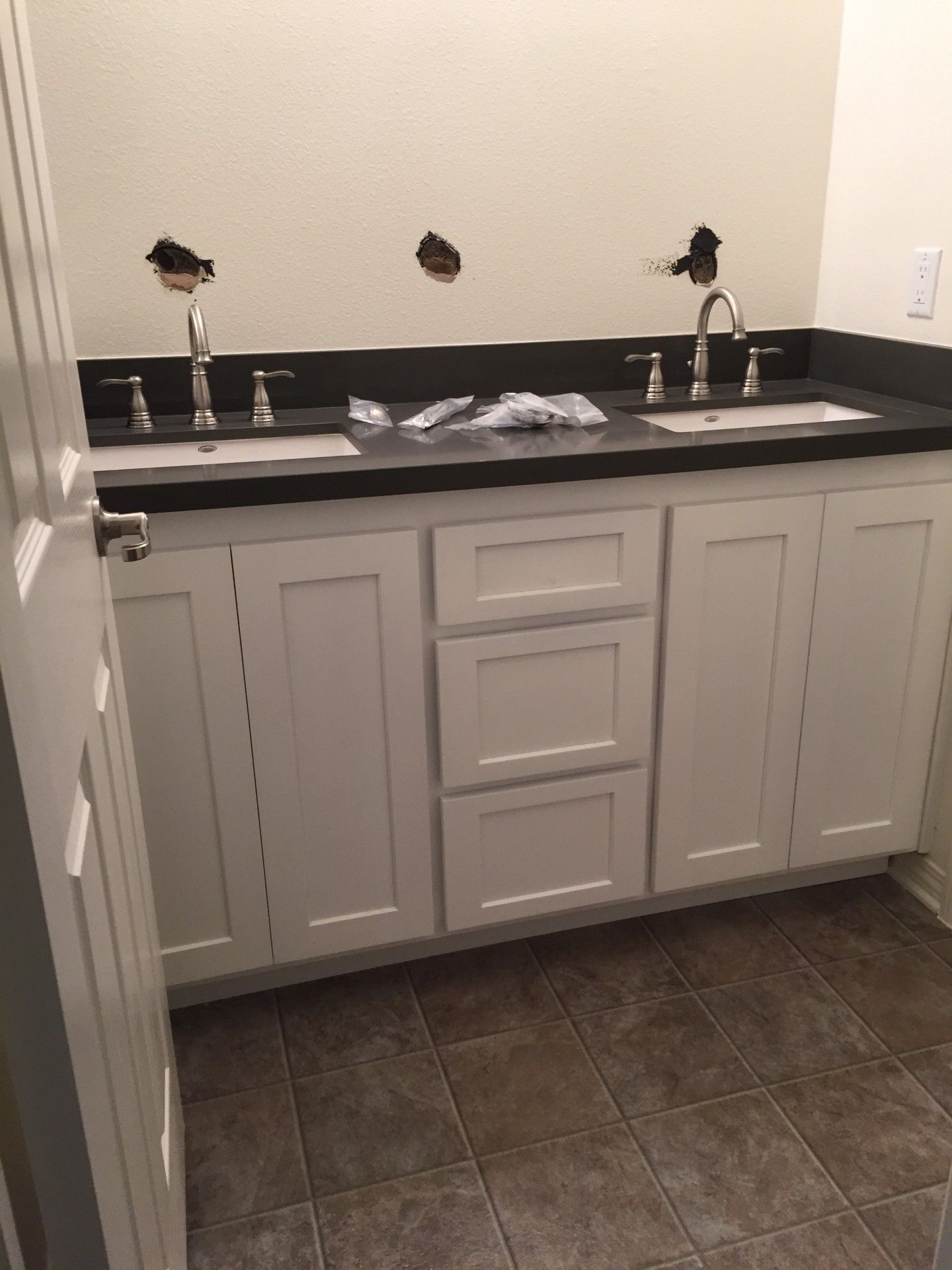 A bathroom with two sinks and white cabinets.
