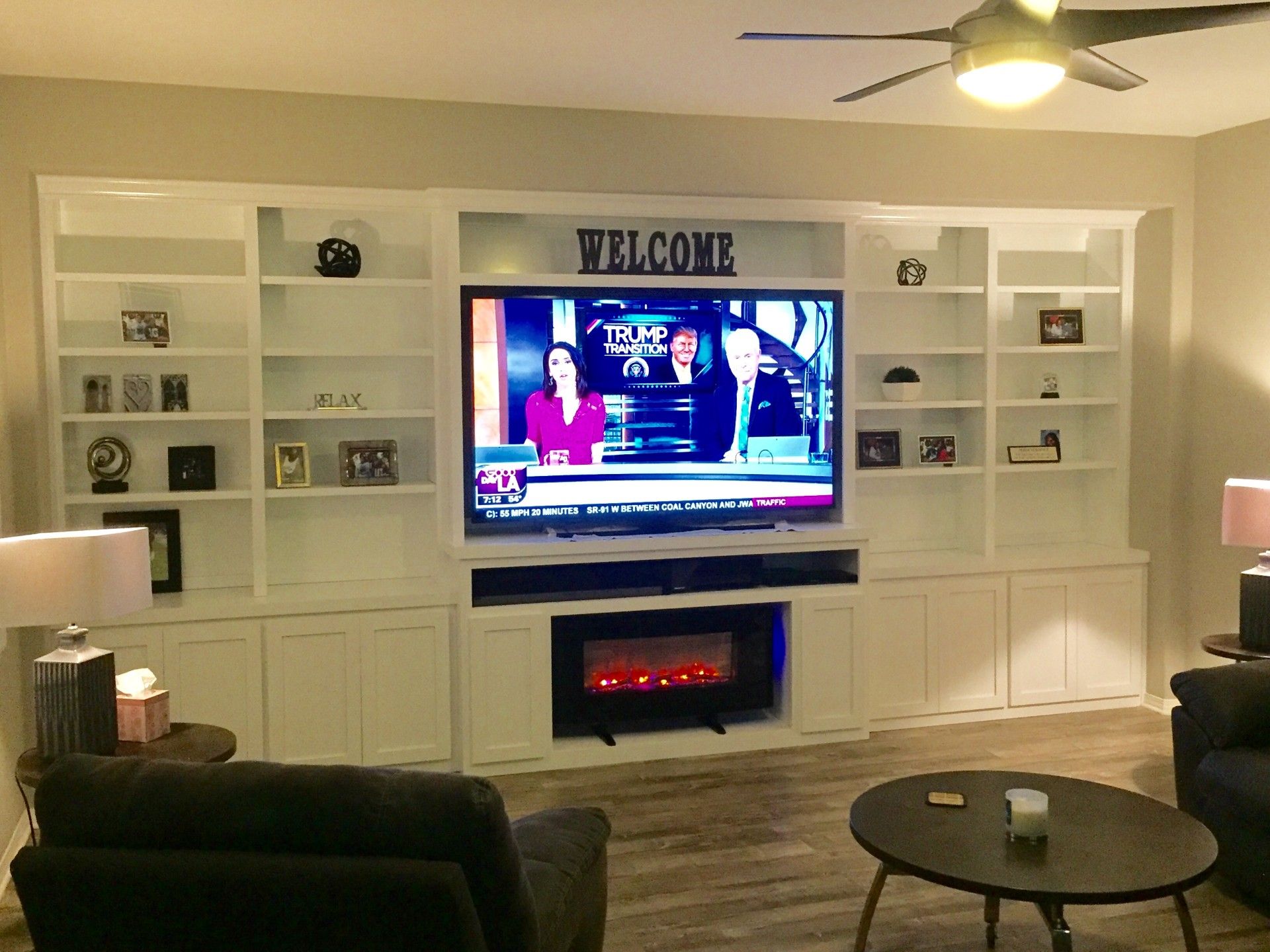 A living room with a welcome sign above the television