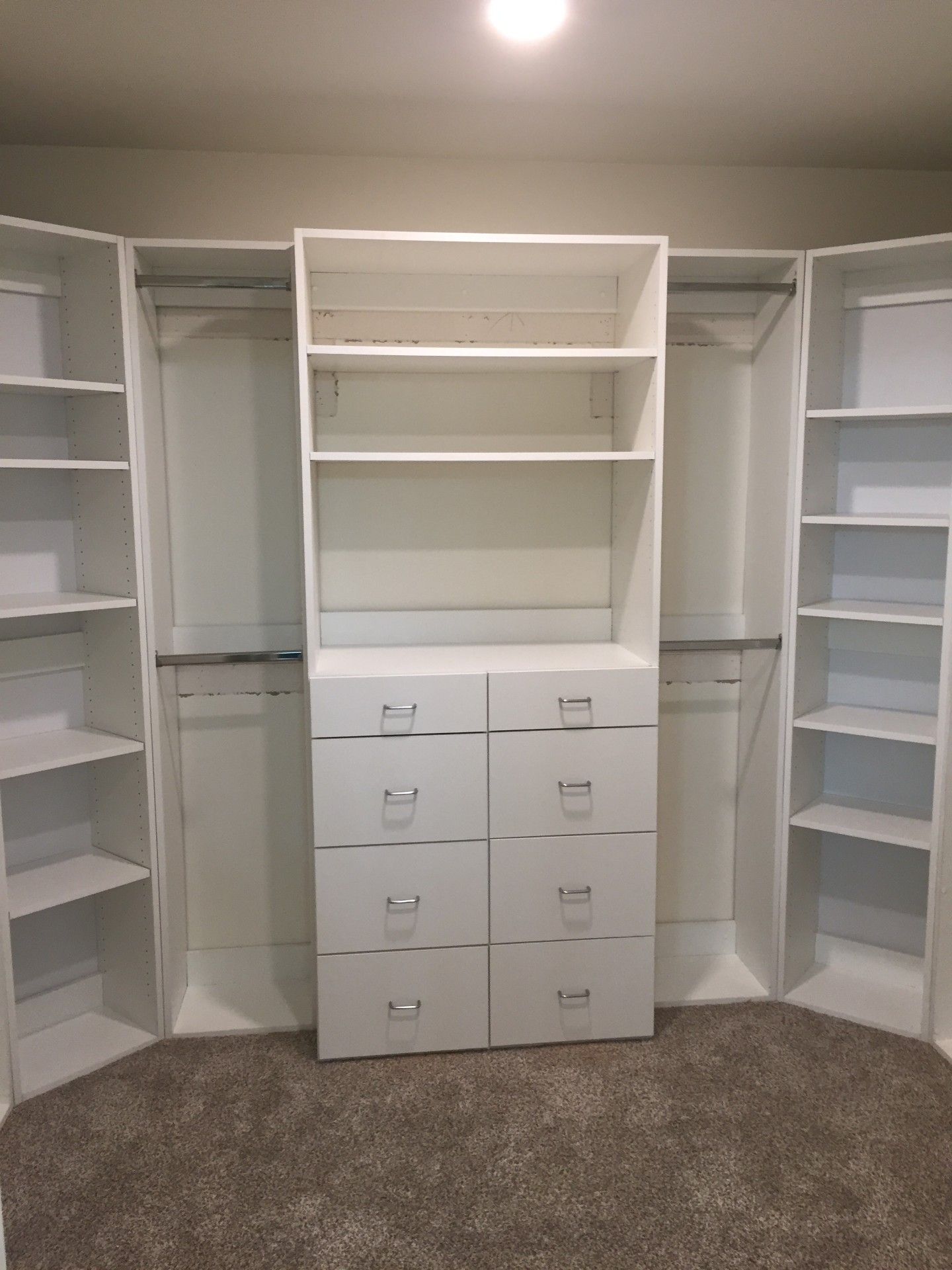 A walk in closet with lots of shelves and drawers