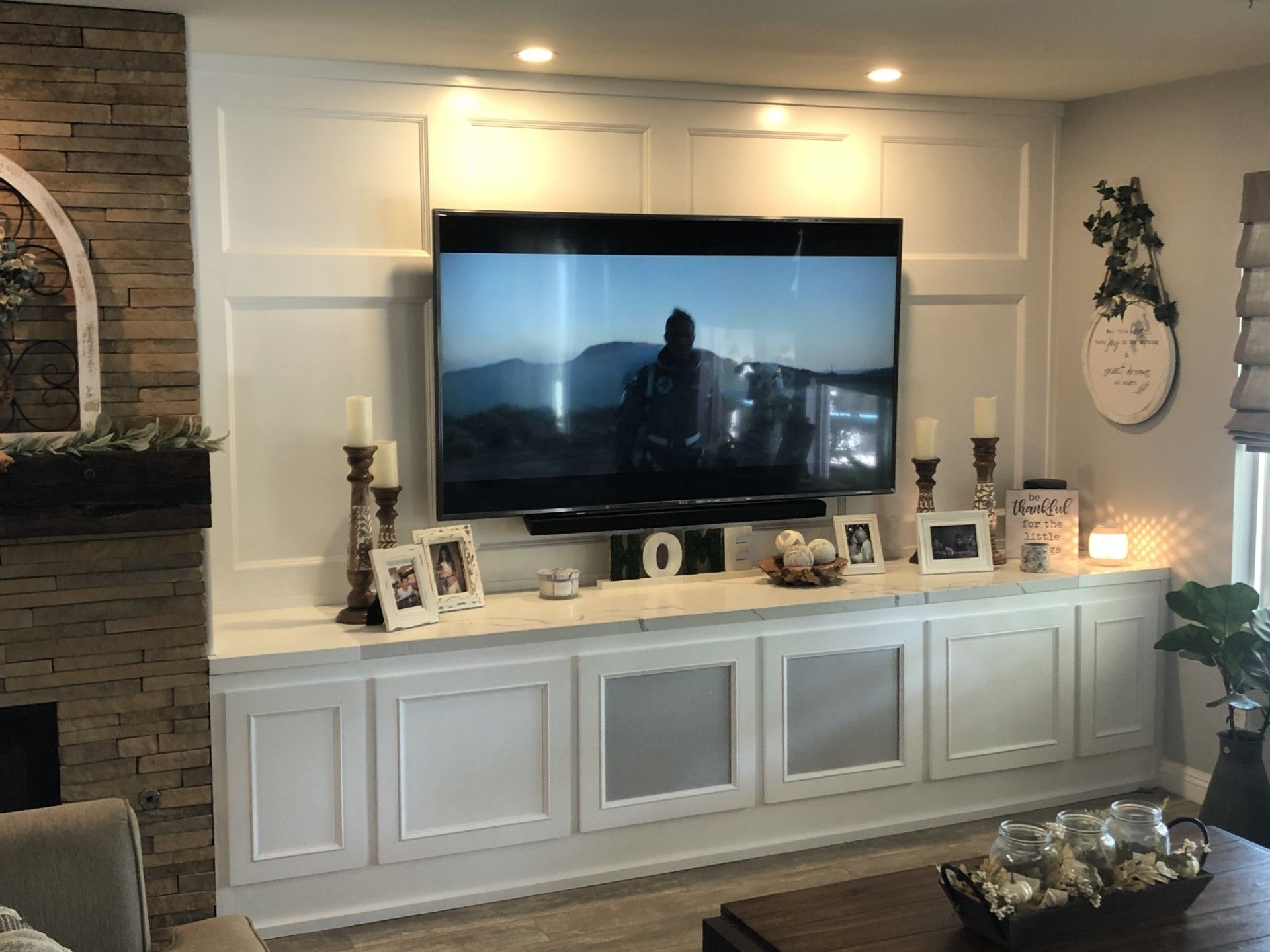 A living room with a large flat screen tv mounted on the wall.