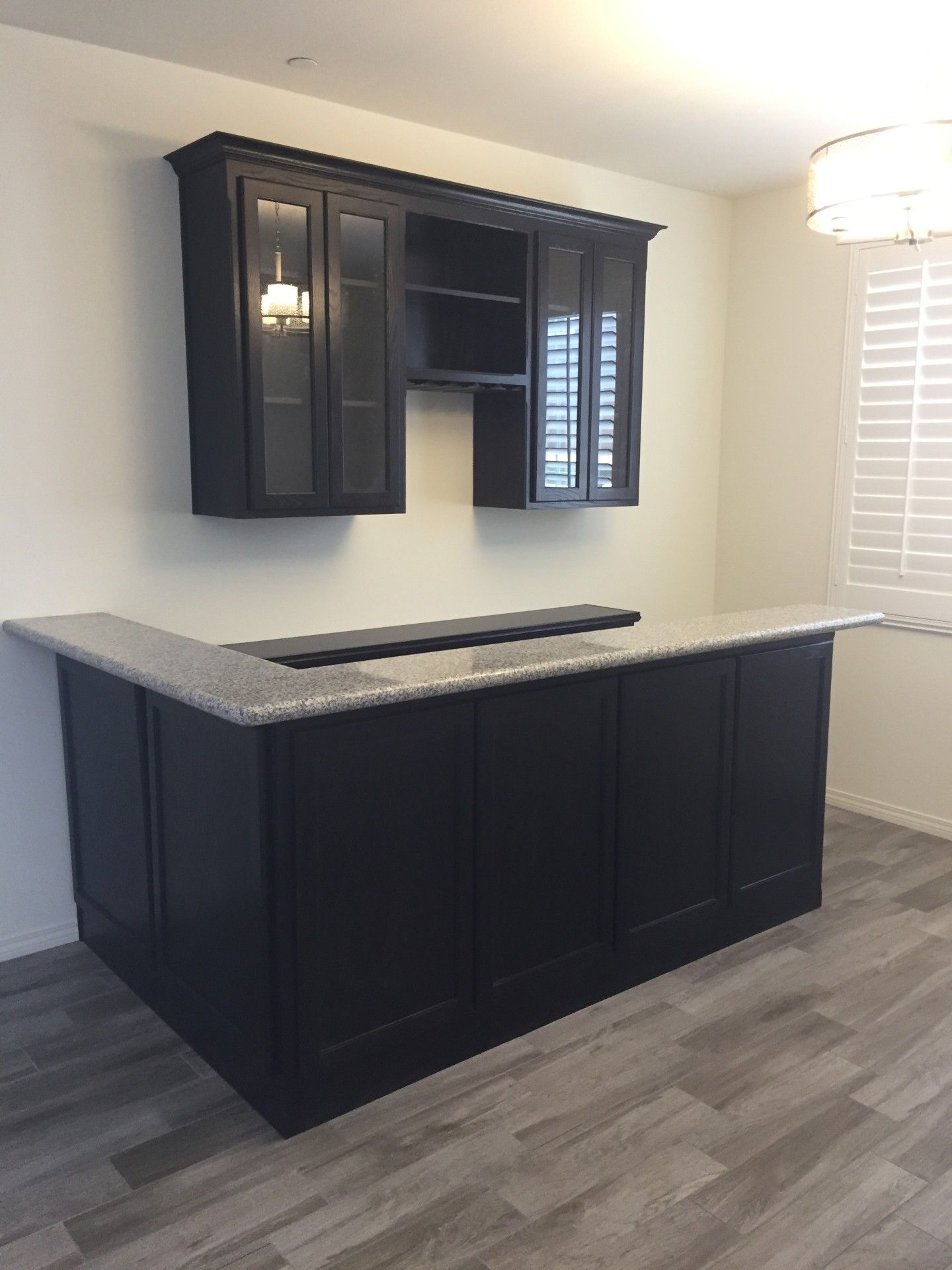 A kitchen with black cabinets and granite counter tops