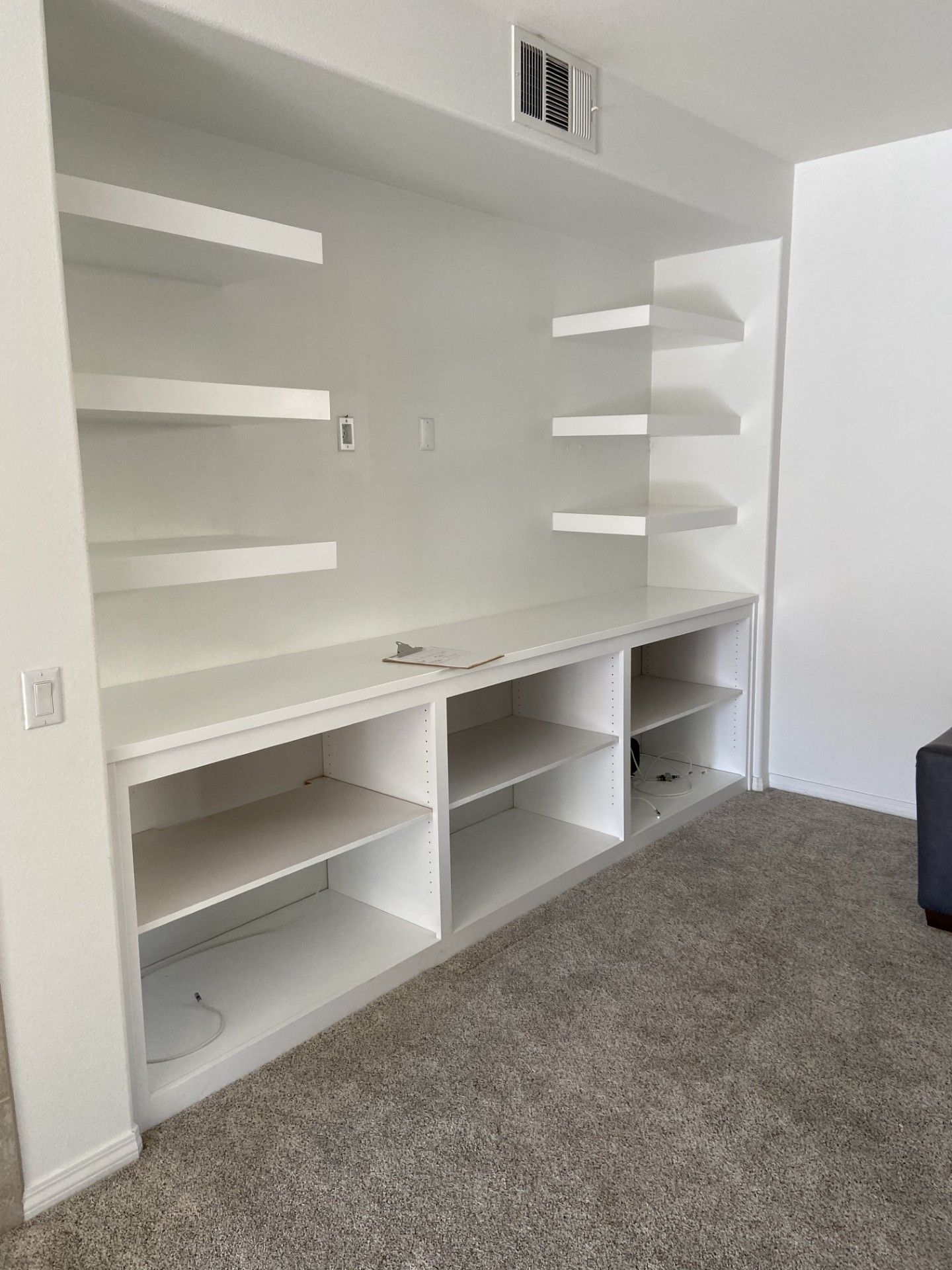 A living room with a lot of shelves and a couch.