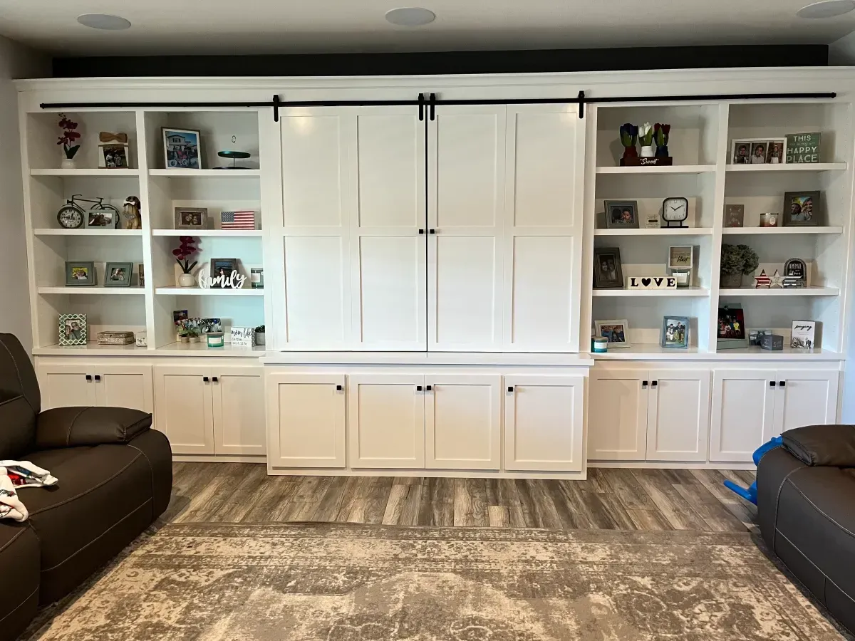 A living room with a lot of shelves and cabinets and a couch.