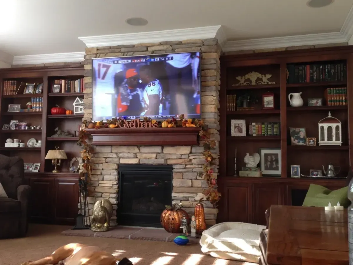 A living room with a fireplace and a flat screen tv