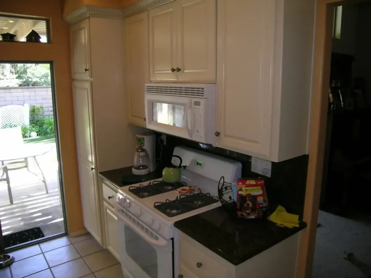 A kitchen with a stove top oven and a microwave