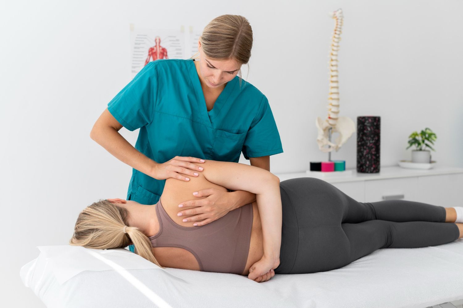 A woman is laying on a bed getting a massage from a nurse.