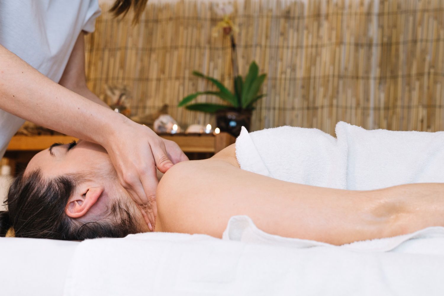 A woman is laying on a bed getting a massage.