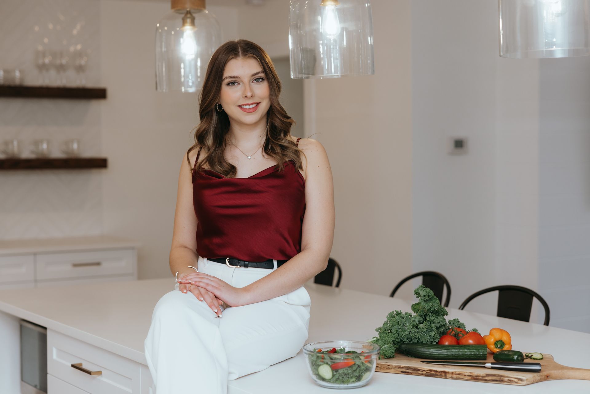 A female dietitian is sitting at a table holding an apple.