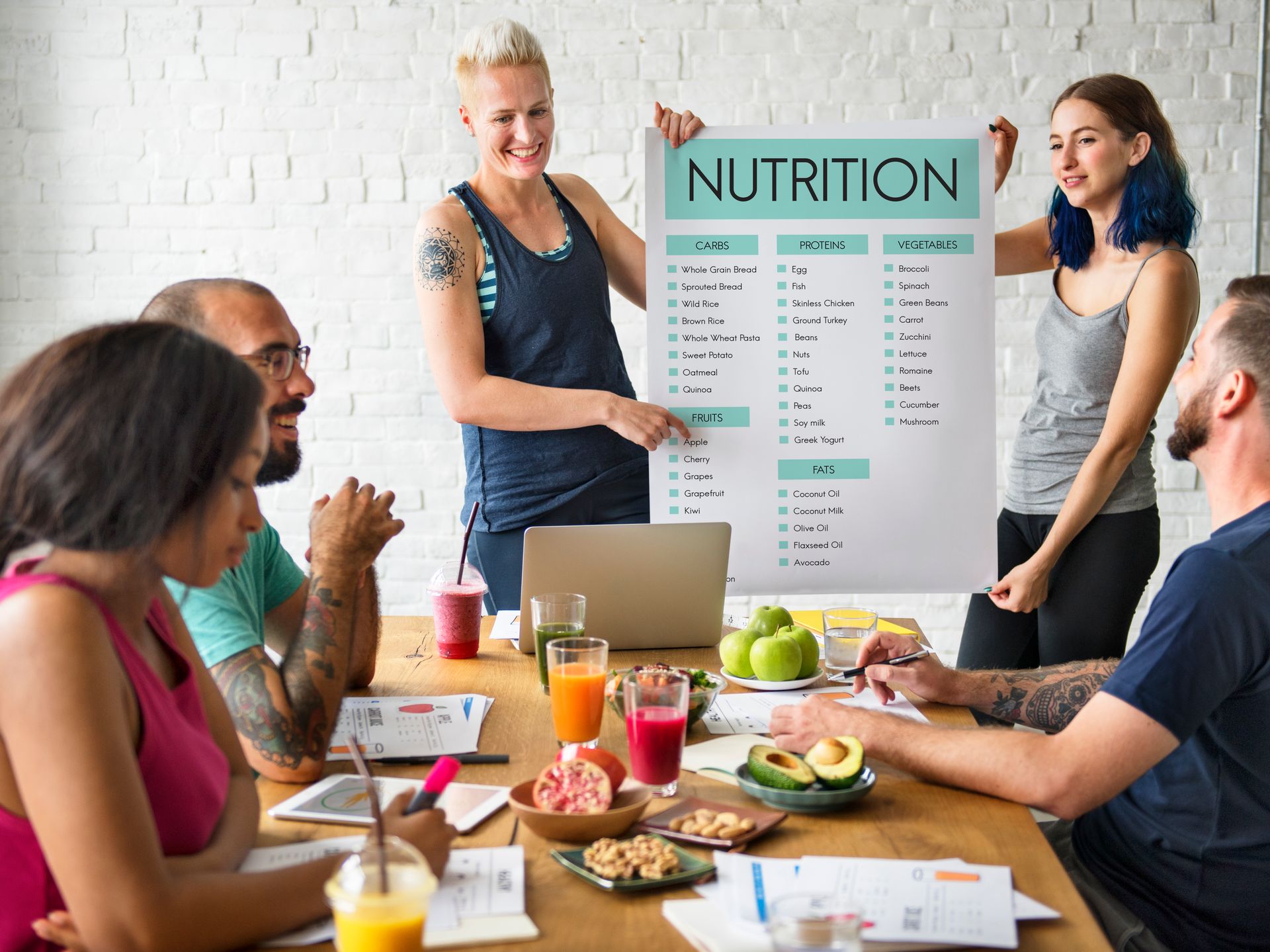 A group of people are sitting around a table holding a sign that says nutrition.