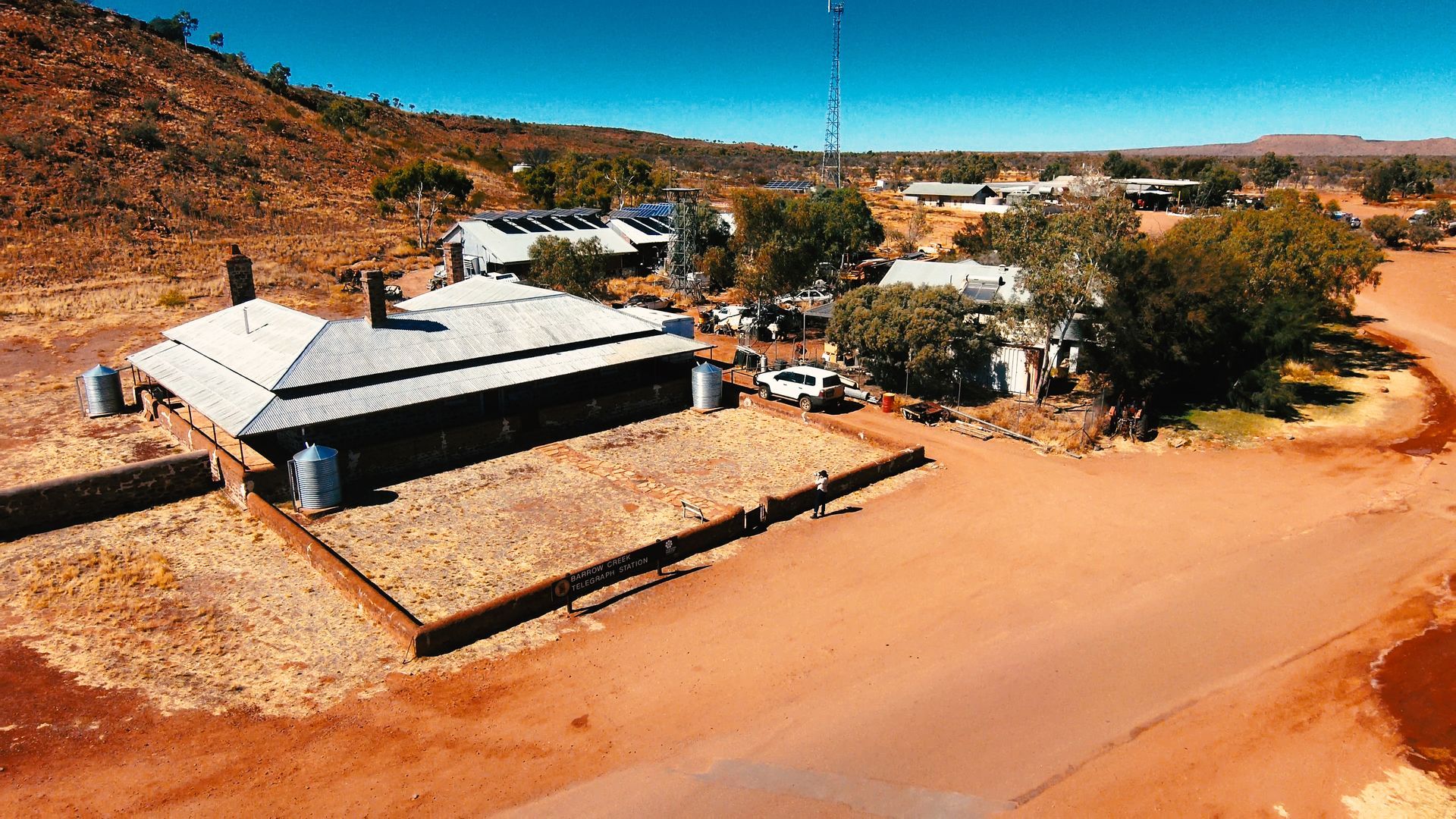 An aerial view of a house in the middle of a dirt field.