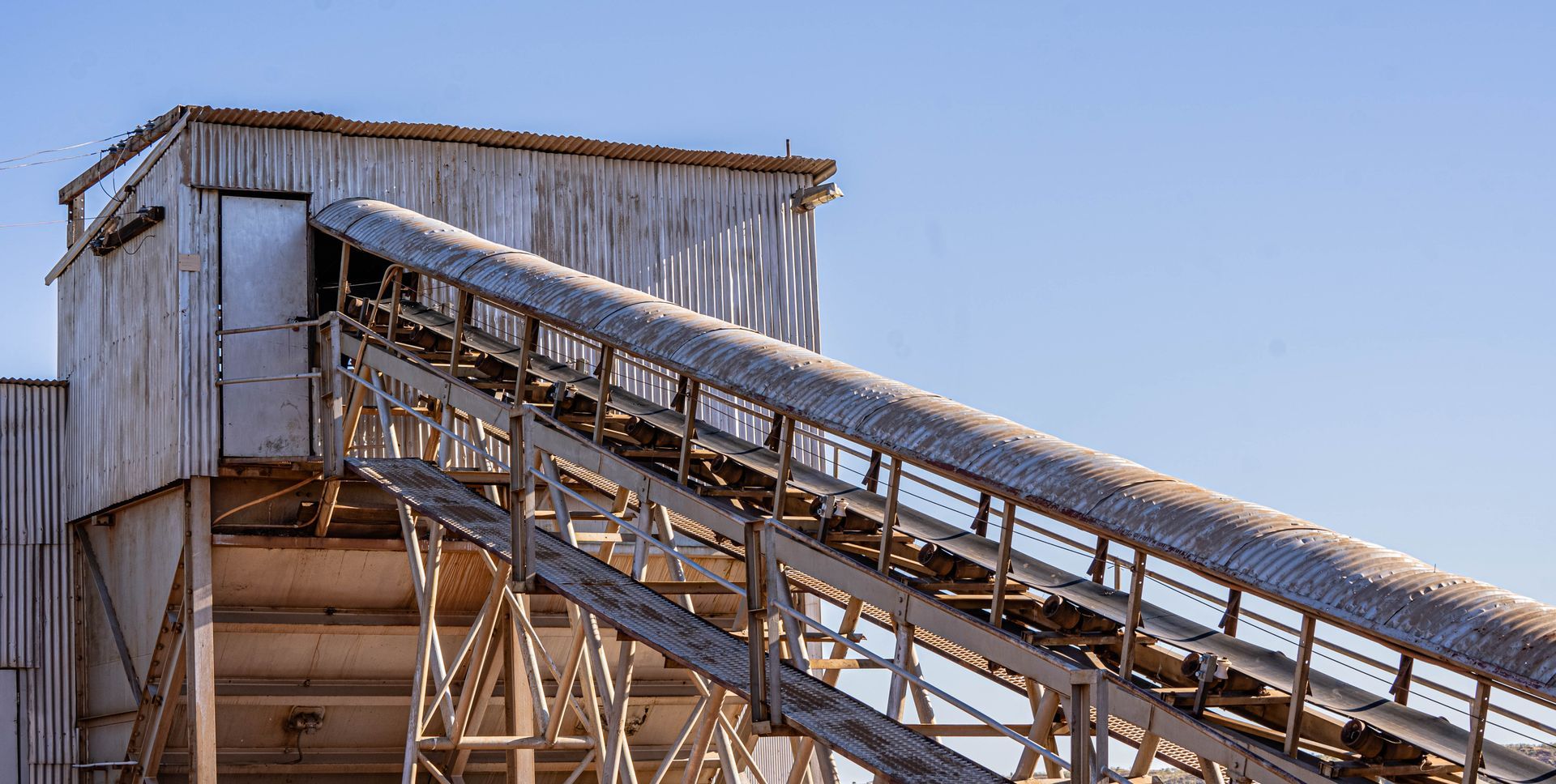 A conveyor belt is going up a building in a factory.