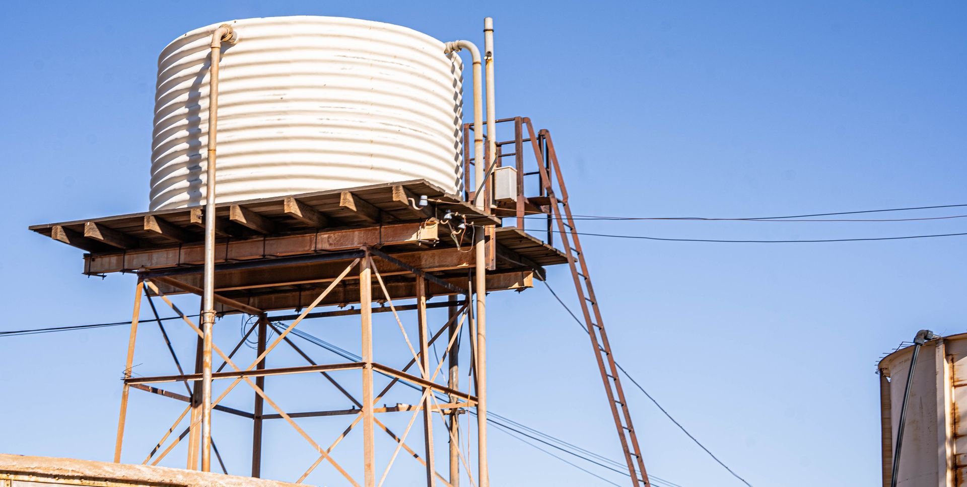 A water tower with a ladder on top of it.