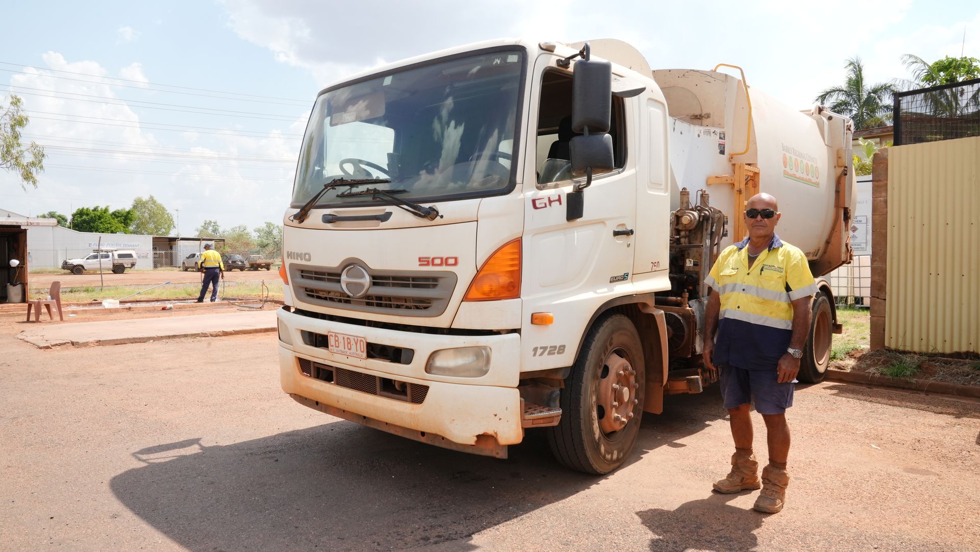A man is standing in front of a white truck.
