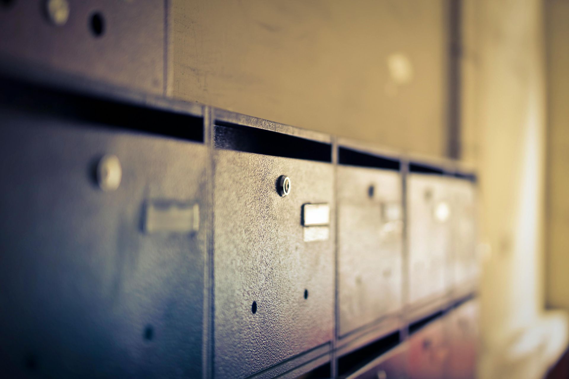 A row of mailboxes on a wall in a building.