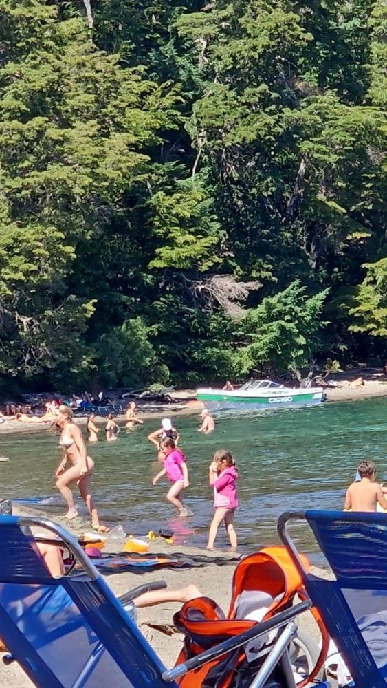 A group of people are playing in the water on a beach.