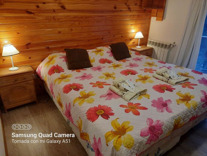 A bedroom with a large bed and a samsung quad camera