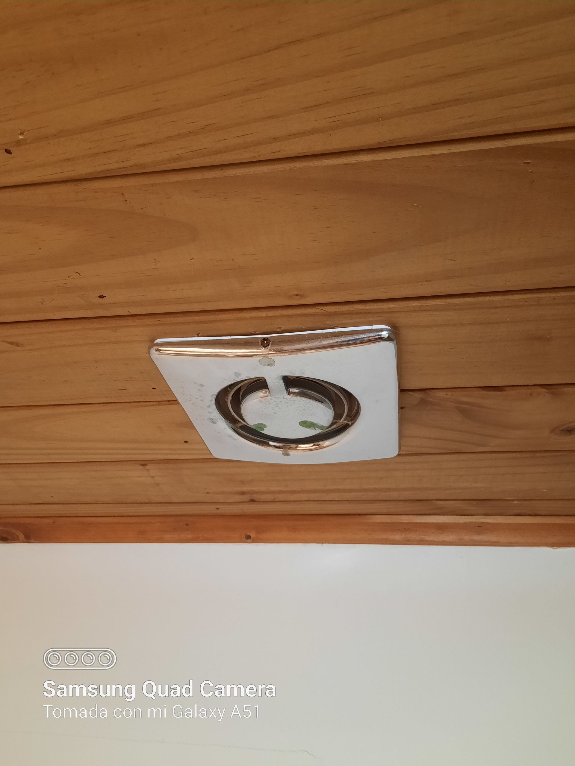 A close up of a light switch on a wooden ceiling.