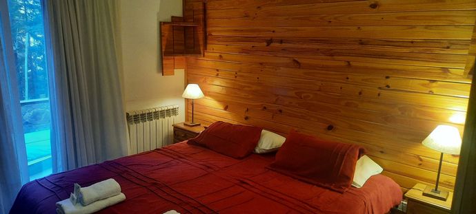 A bedroom with a large bed and a wooden wall.