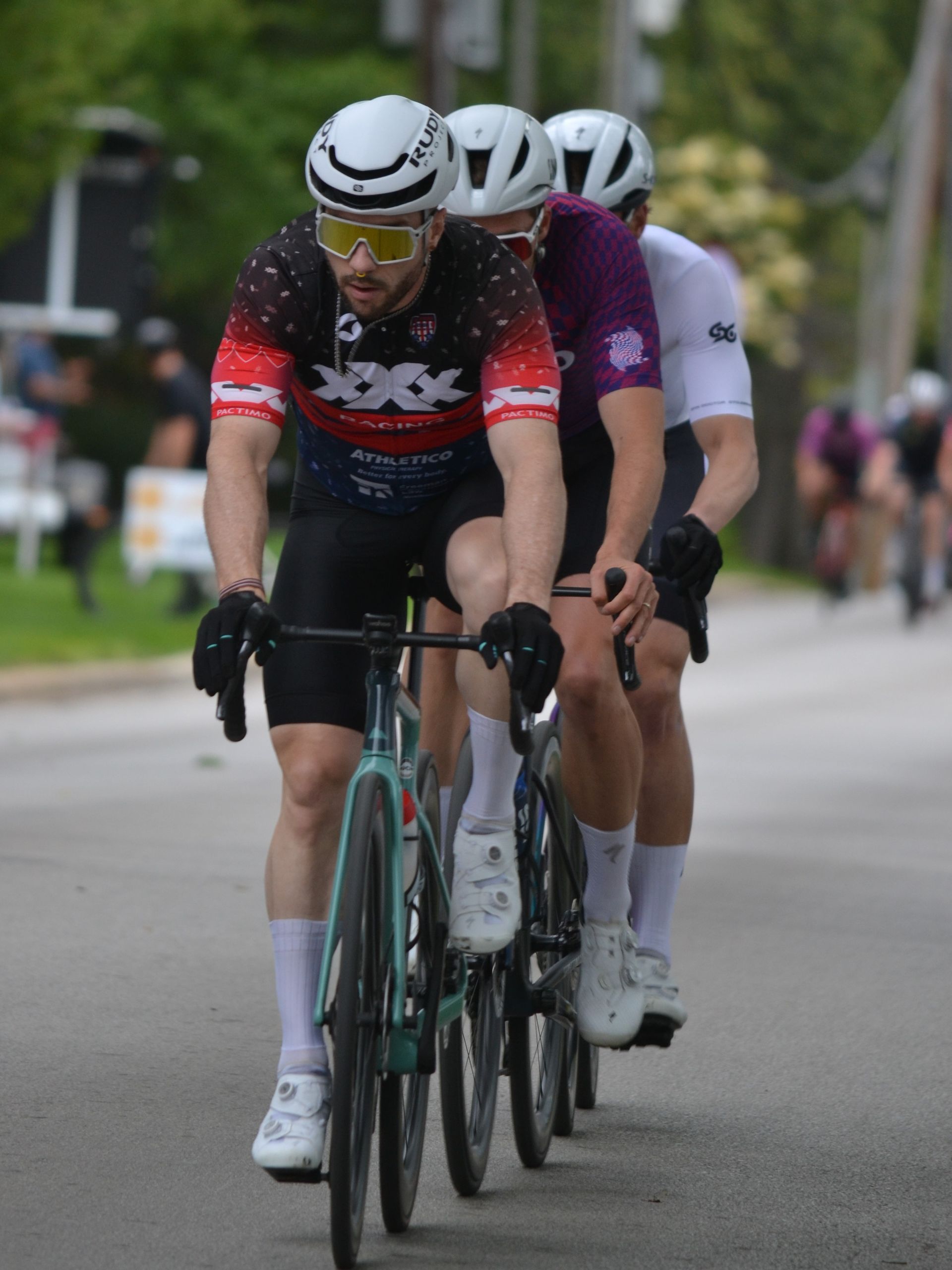 A group of men are riding bicycles down a street