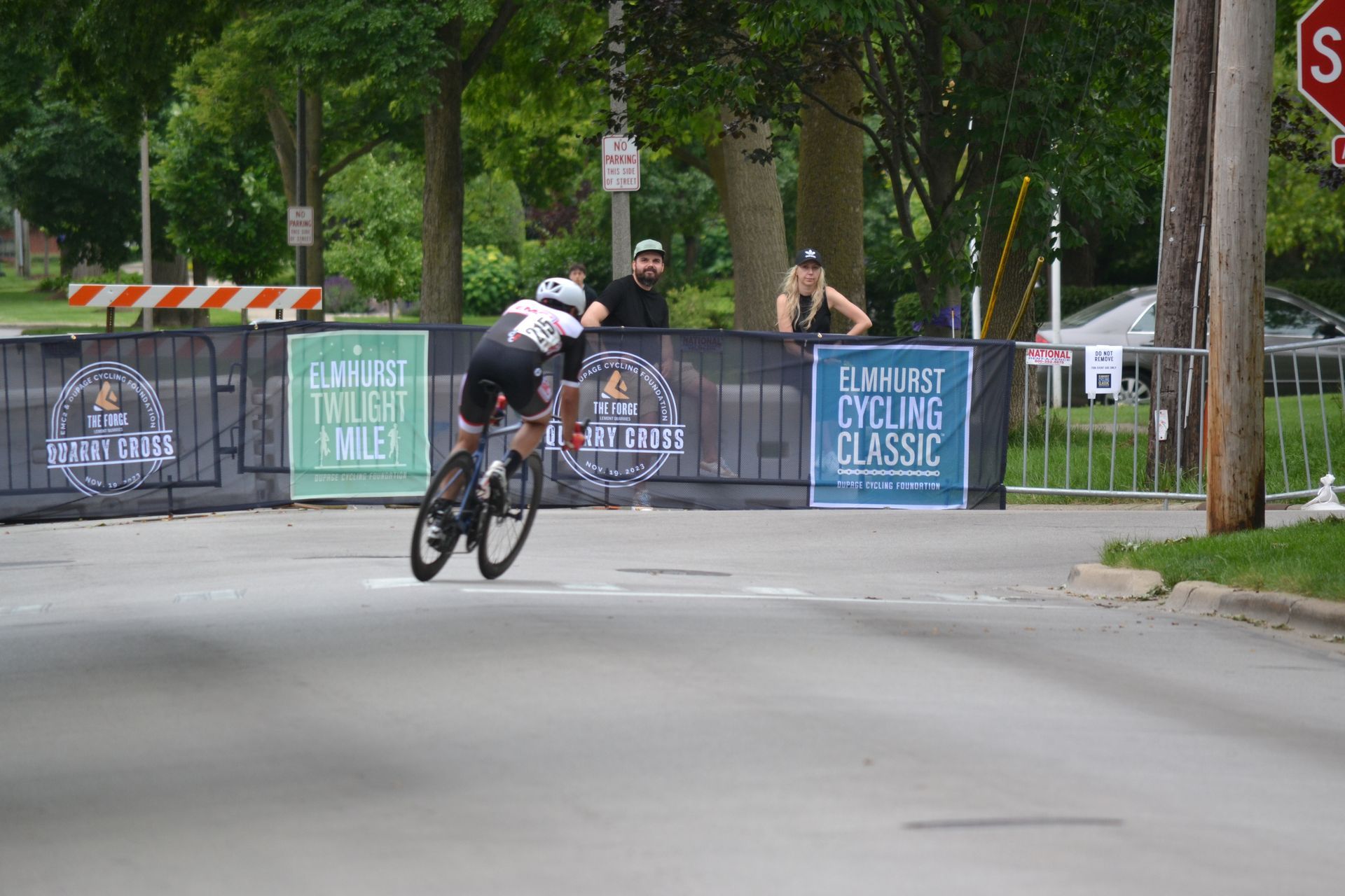 A person is riding a bike down a street in front of a sign that says cycling classic