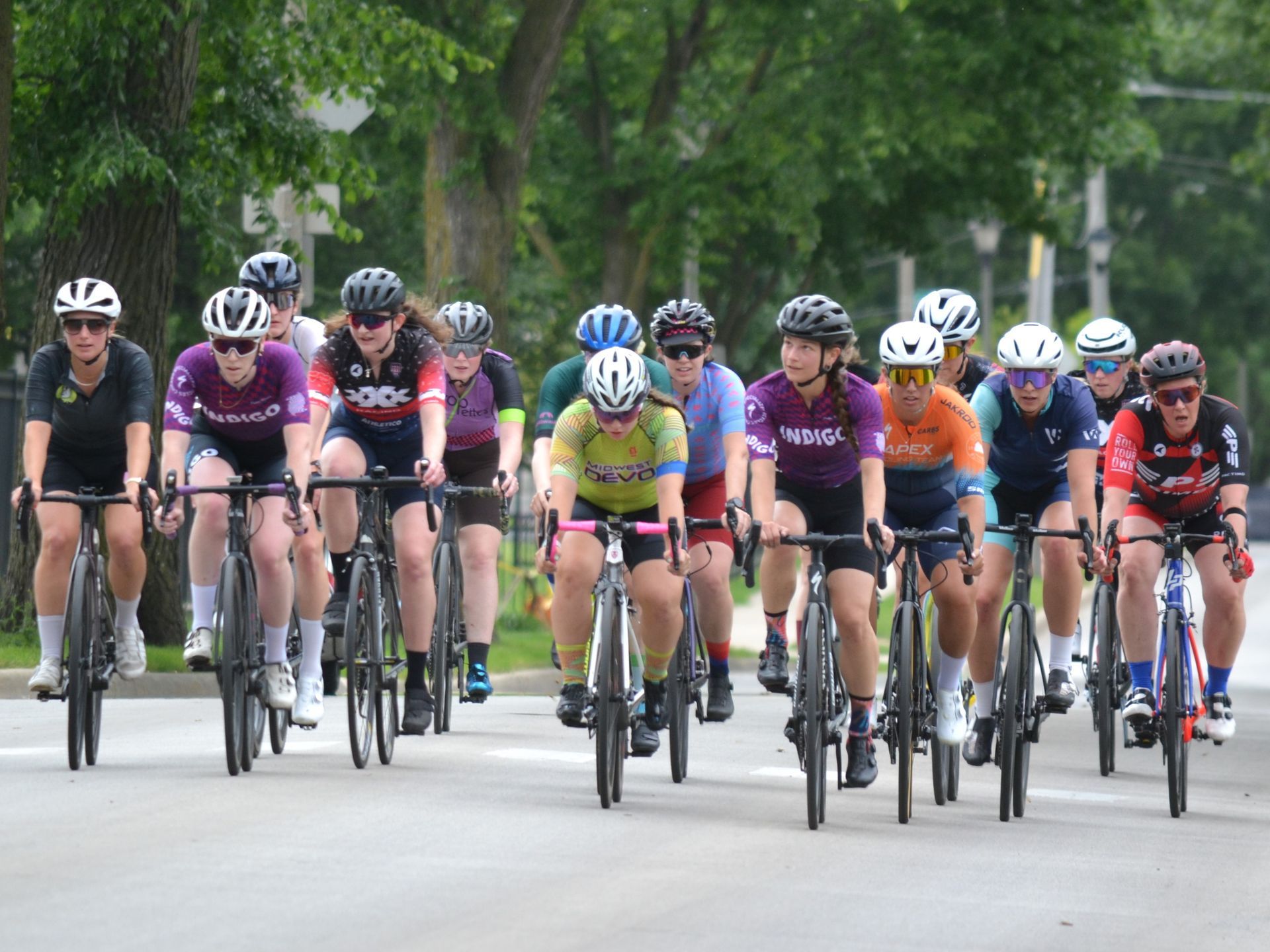 A group of people are riding bicycles down a street