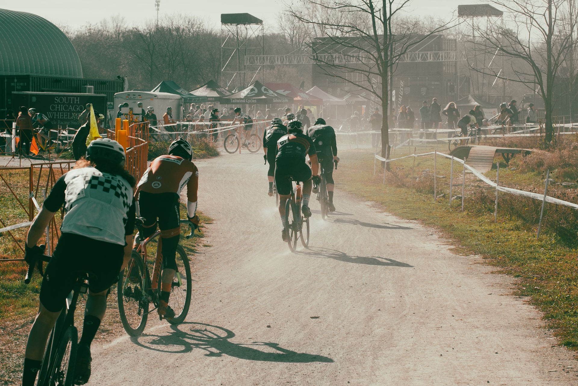 A group of people are riding bicycles down a dirt road.