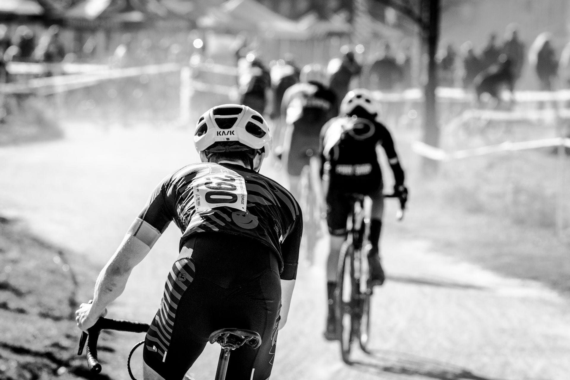 A group of people are riding bicycles down a dirt road.