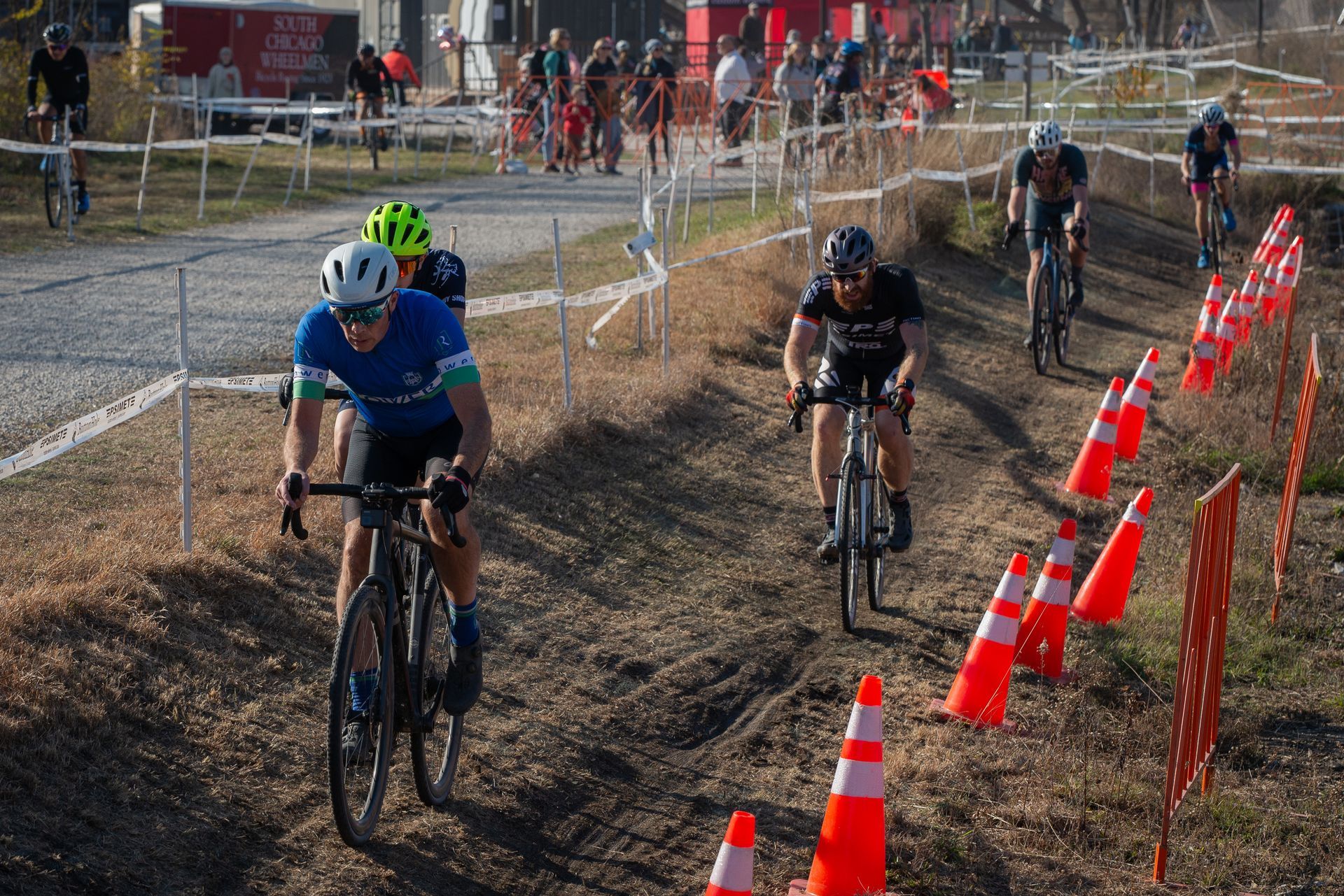 A group of people are riding bicycles down a dirt road.
