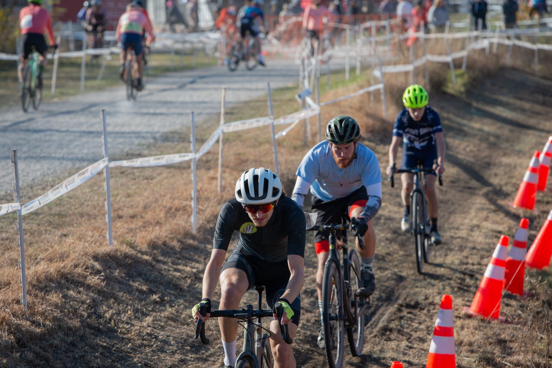 A group of people are riding bicycles down a dirt road.