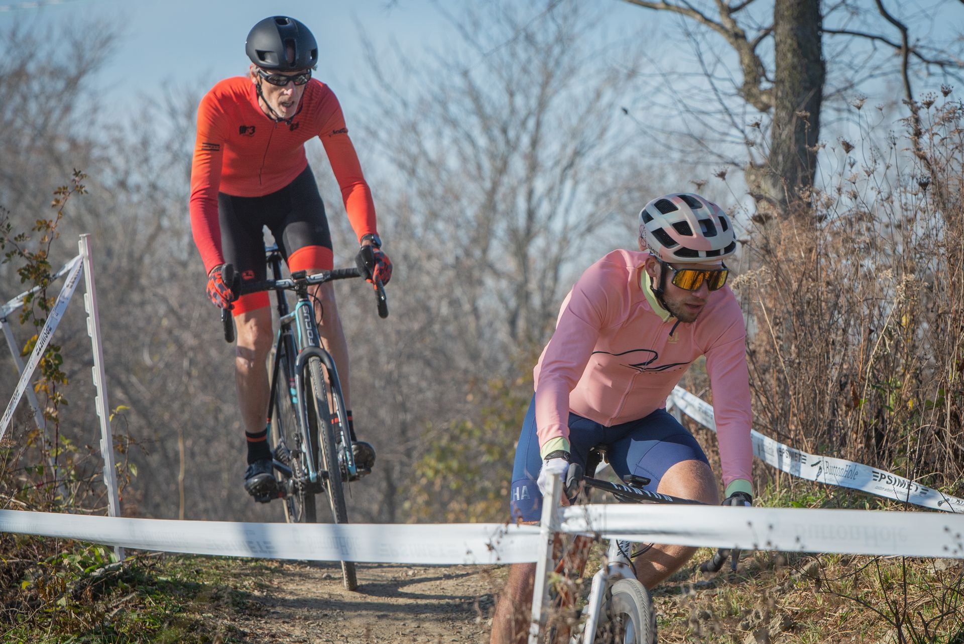 A man and a woman are riding bicycles on a dirt road.