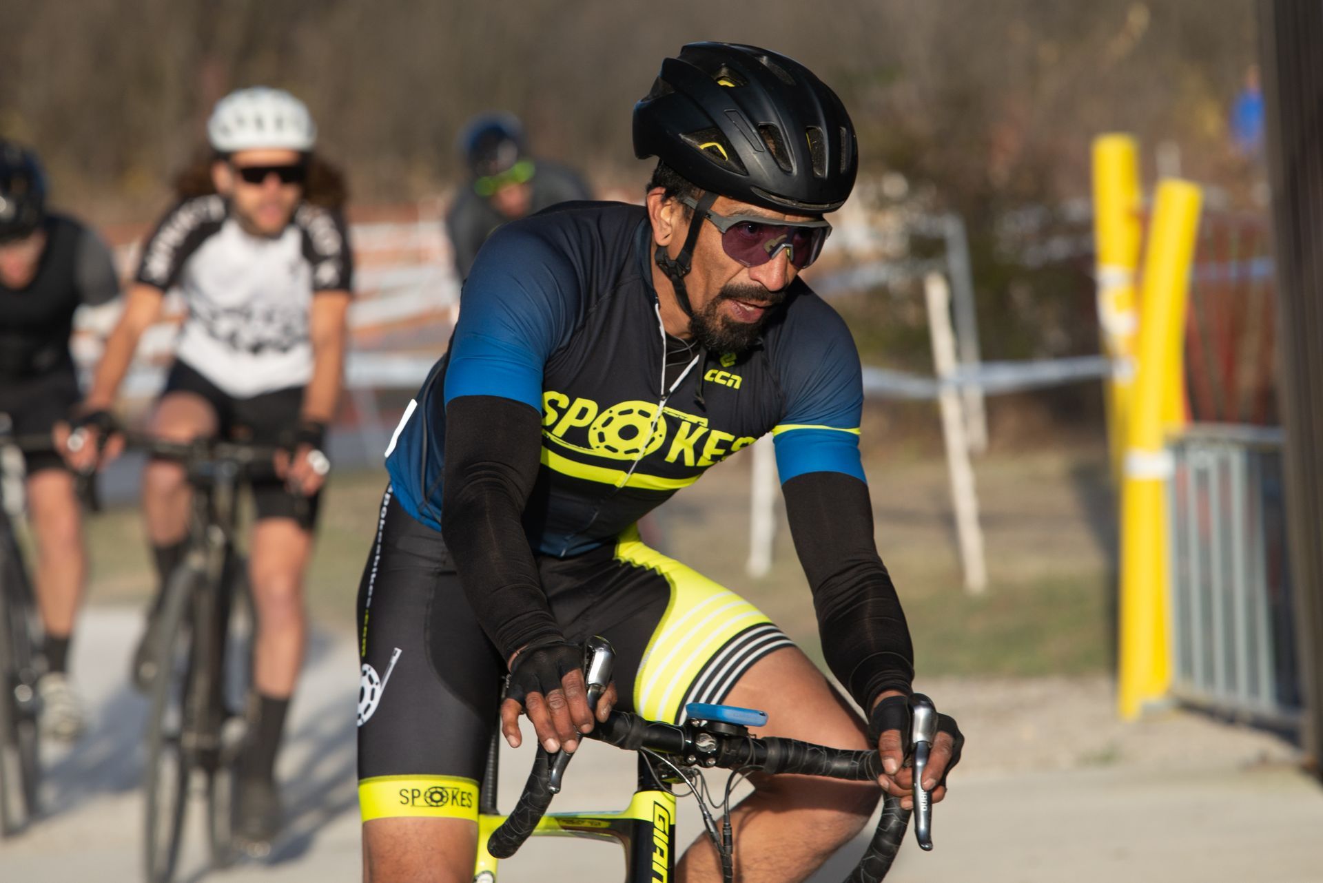 A man wearing a helmet and sunglasses is riding a bike.