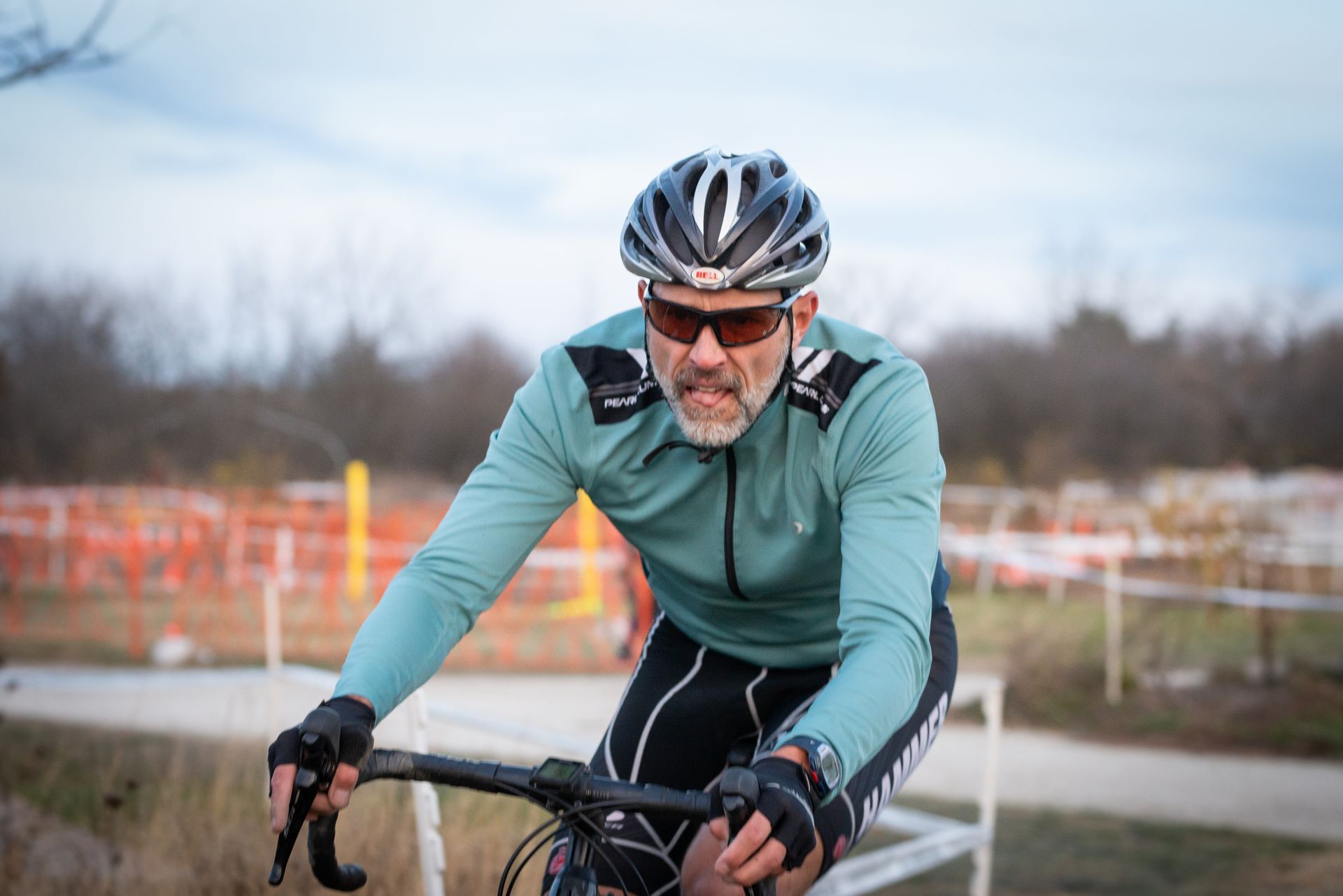 A man wearing a helmet and sunglasses is riding a bike.